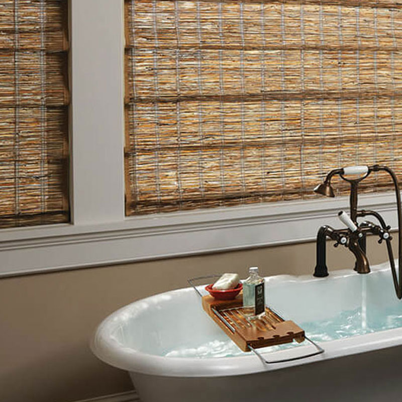 photo of rattan window shades in a bathroom next to the tub.